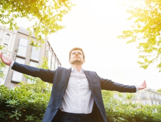 low-angle-view-businessman-standing-front-building-outstretching-his-arms (1)